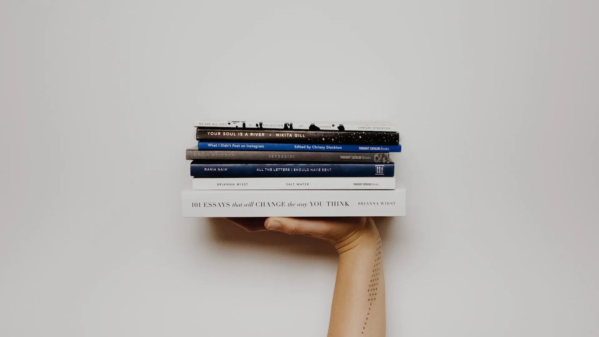 Hand holding a stack of books